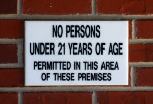 A sign on the side of a brick wall.