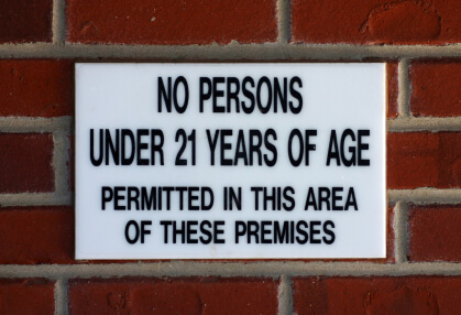 A sign on the side of a brick wall.