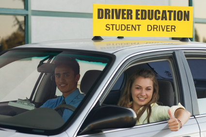 A man and woman in the driver 's seat of a car.